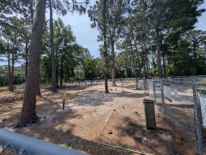 Empie Park Dog Park with trees, watering bowls and fenced in areas.