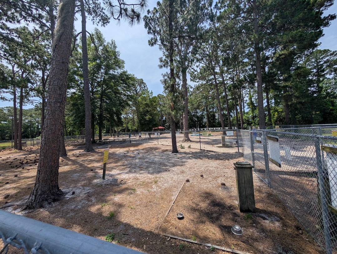 Empie Park Dog Park with trees, watering bowls and fenced in areas.